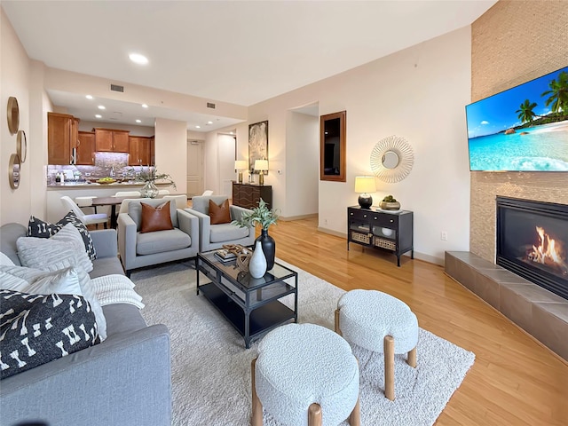 living room with light hardwood / wood-style flooring and a tile fireplace