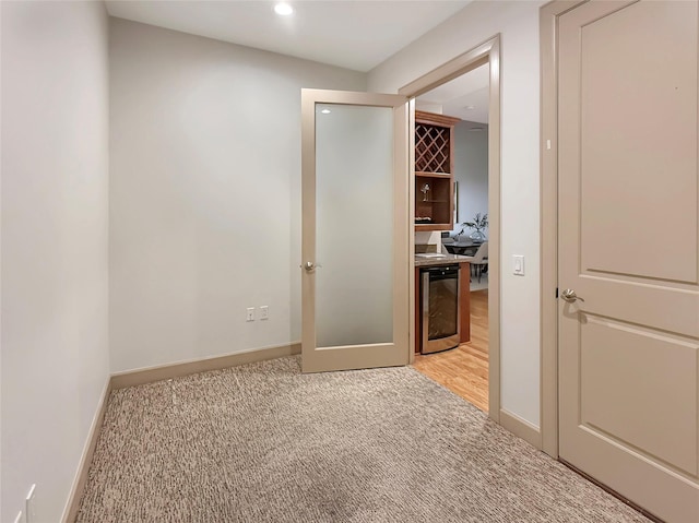 hallway featuring light carpet and beverage cooler