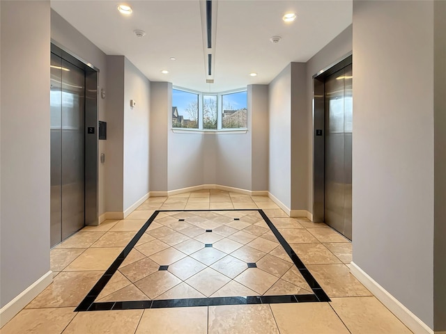 corridor featuring elevator and light tile patterned floors