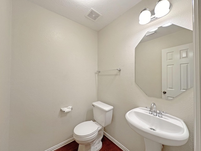 bathroom featuring sink, hardwood / wood-style floors, a textured ceiling, and toilet