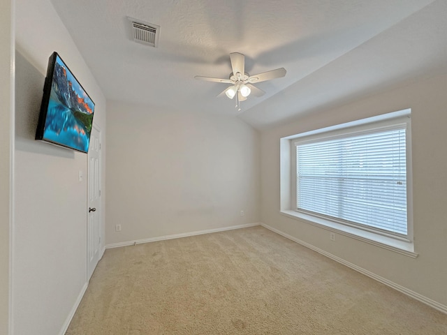 carpeted empty room featuring lofted ceiling and ceiling fan