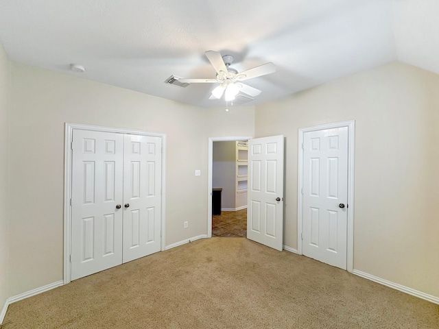 unfurnished bedroom with ceiling fan, lofted ceiling, and carpet floors