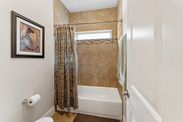 bathroom featuring toilet and shower / bath combination with curtain