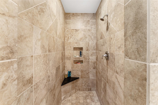 interior details featuring tiled shower