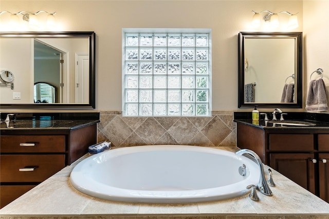 bathroom with tiled bath and vanity