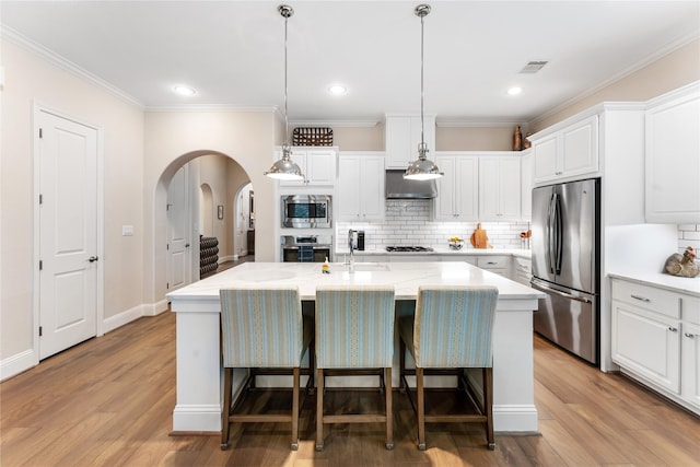 kitchen featuring a center island with sink, appliances with stainless steel finishes, and white cabinetry