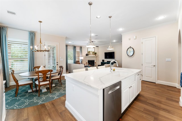 kitchen featuring white cabinets, dishwasher, an island with sink, sink, and light stone counters