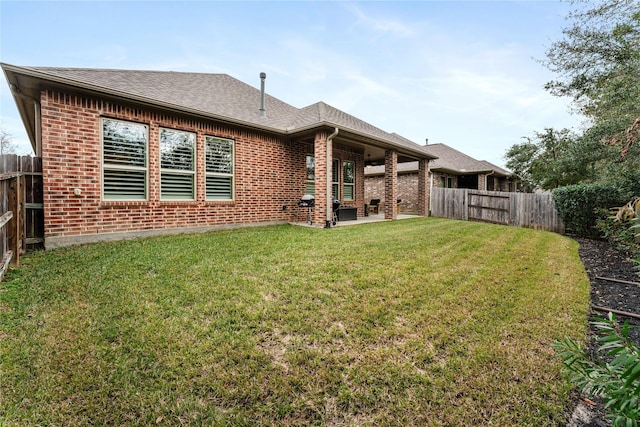 rear view of house featuring a patio area and a yard