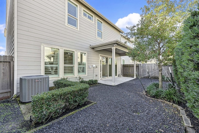 rear view of property featuring a patio area and central air condition unit