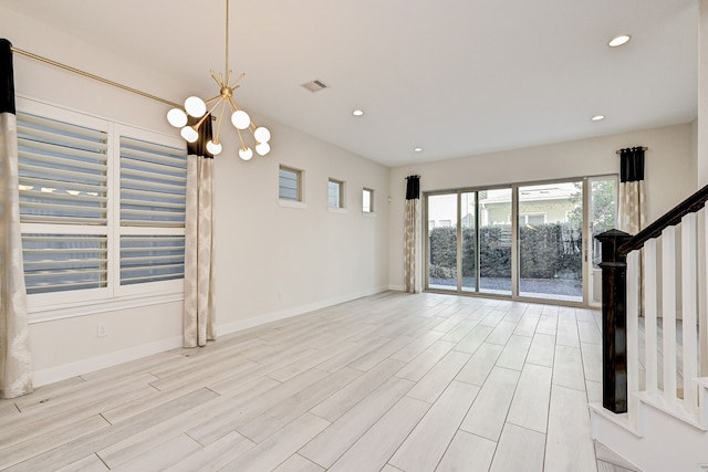 unfurnished living room with a notable chandelier and light hardwood / wood-style flooring