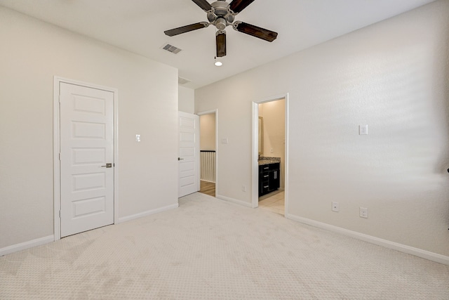 unfurnished bedroom with ceiling fan, a closet, light colored carpet, and ensuite bath