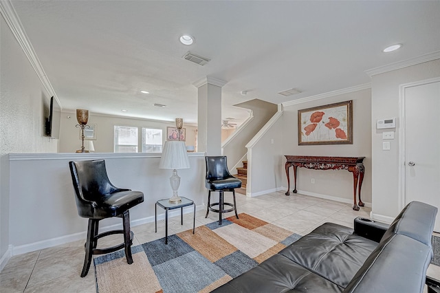 living room featuring light tile patterned flooring, crown molding, and decorative columns