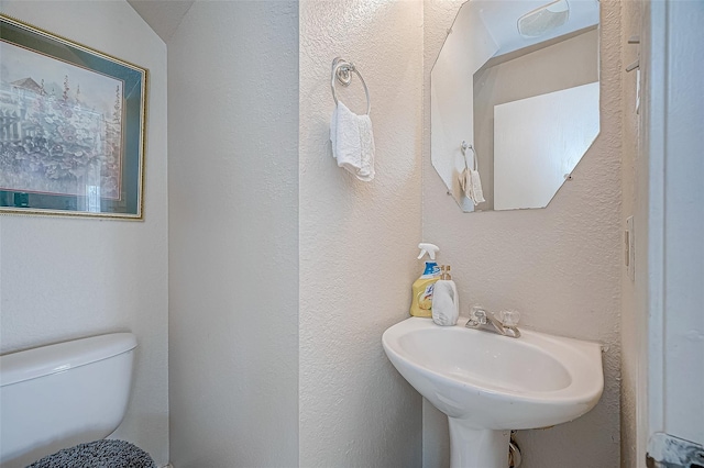 bathroom with vaulted ceiling, toilet, and sink