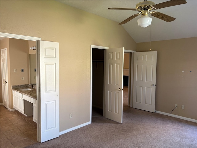 unfurnished bedroom with ceiling fan, light colored carpet, lofted ceiling, built in desk, and sink