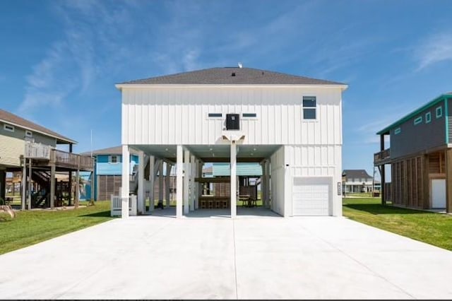 back of property featuring a garage, a yard, and a carport