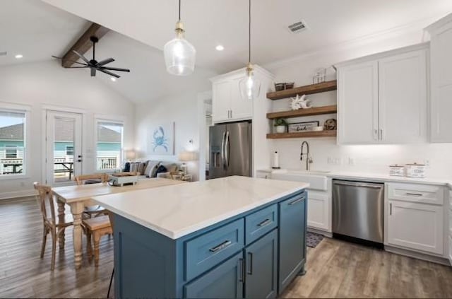 kitchen featuring appliances with stainless steel finishes, a sink, open shelves, ceiling fan, and wood finished floors