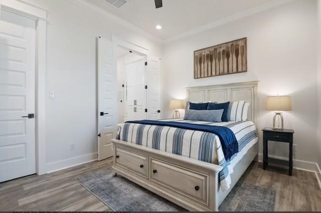 bedroom with dark wood-type flooring, ceiling fan, and ornamental molding