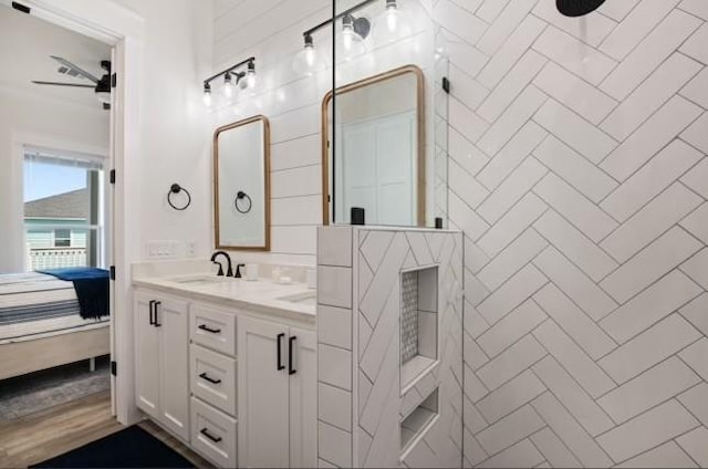 bathroom featuring tiled shower and vanity