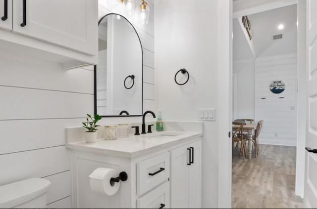 bathroom featuring hardwood / wood-style flooring, toilet, and vanity