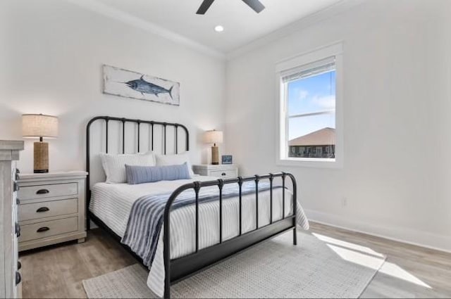 bedroom featuring ceiling fan, crown molding, and light hardwood / wood-style floors