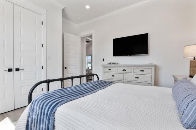 carpeted bedroom with a closet and ornamental molding