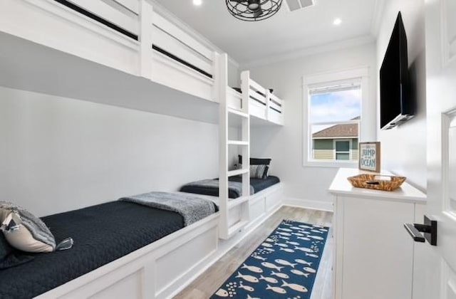 bedroom with ornamental molding and light hardwood / wood-style flooring