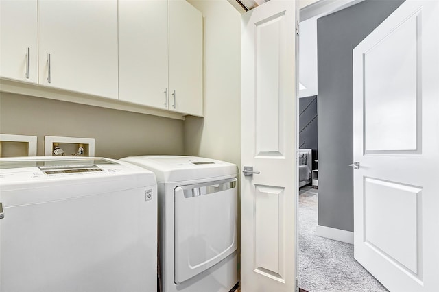 laundry room featuring cabinets, separate washer and dryer, and light colored carpet