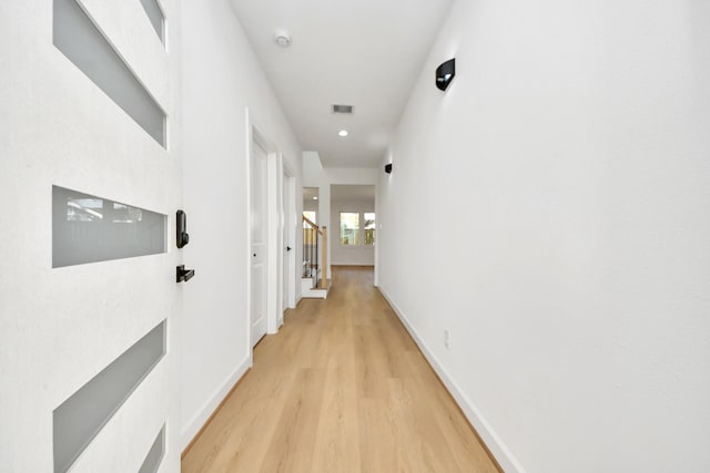 hallway with light hardwood / wood-style floors