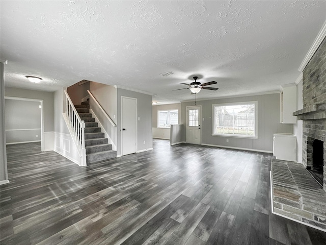 unfurnished living room with a textured ceiling, a fireplace, dark hardwood / wood-style floors, ceiling fan, and crown molding