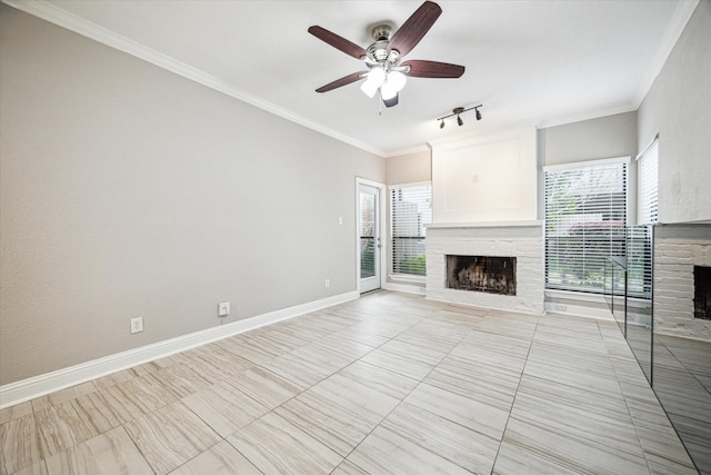 unfurnished living room with light tile patterned floors, ceiling fan, a fireplace, ornamental molding, and track lighting