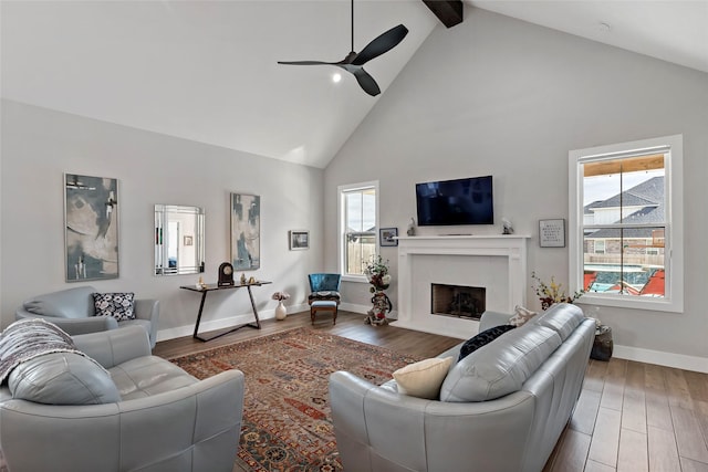 living room featuring ceiling fan, wood-type flooring, beamed ceiling, and high vaulted ceiling