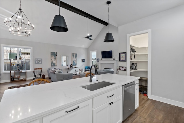 kitchen featuring stainless steel dishwasher, hanging light fixtures, beam ceiling, white cabinets, and sink