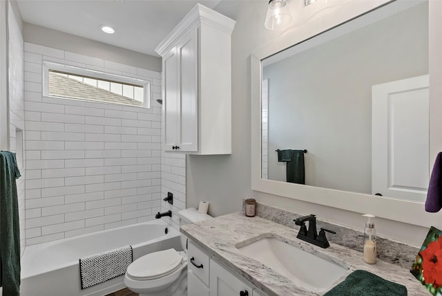 full bathroom featuring tiled shower / bath combo, vanity, and toilet