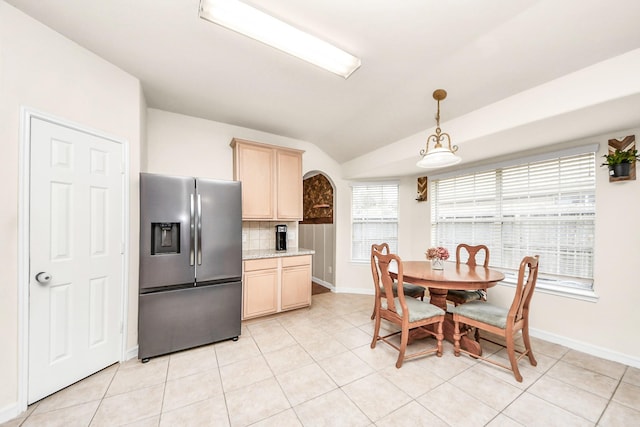 kitchen featuring hanging light fixtures, tasteful backsplash, stainless steel fridge with ice dispenser, vaulted ceiling, and light brown cabinets