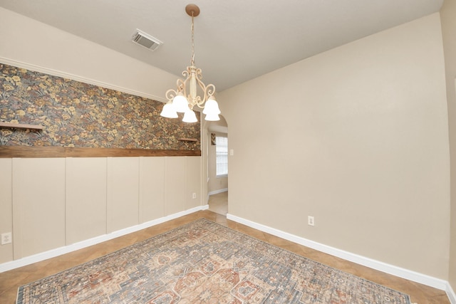 spare room featuring visible vents, baseboards, and an inviting chandelier