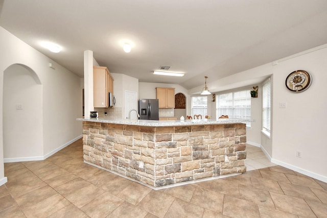 kitchen with arched walkways, light brown cabinets, stainless steel appliances, a peninsula, and visible vents