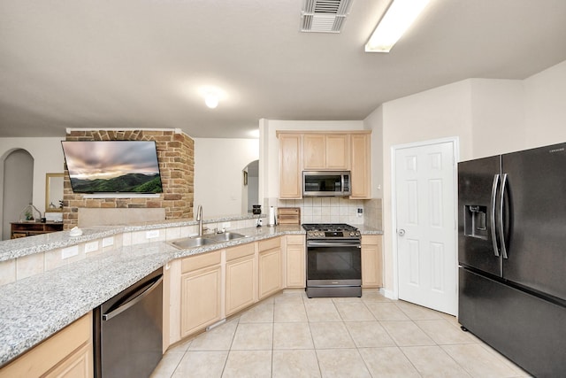 kitchen featuring light tile patterned flooring, a sink, light brown cabinetry, black appliances, and tasteful backsplash