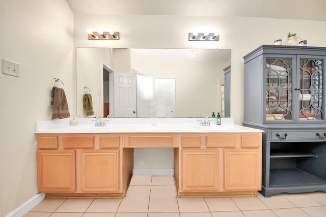 full bathroom with tile patterned flooring, a sink, baseboards, and double vanity