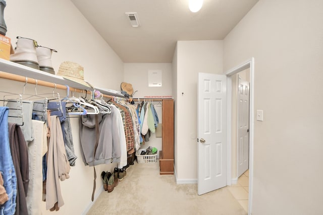 walk in closet featuring visible vents and light colored carpet