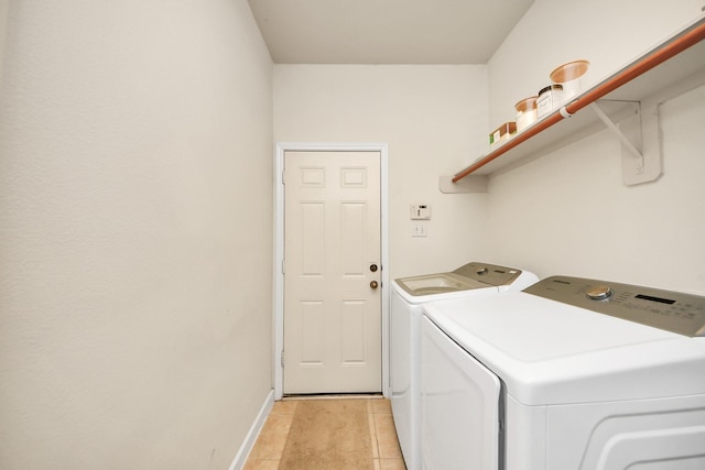 laundry area with light tile patterned floors, laundry area, washer and clothes dryer, and baseboards