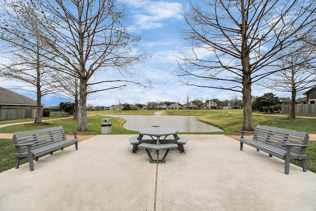 view of community featuring a yard, a patio, and a water view