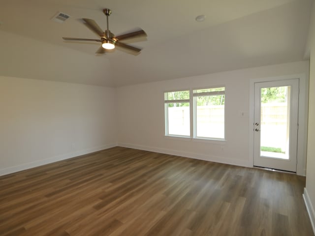 empty room featuring baseboards, visible vents, plenty of natural light, and vaulted ceiling