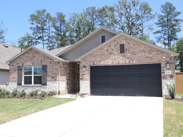 single story home with an attached garage, brick siding, driveway, and stone siding