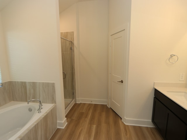 17343 Silver Birch Ct, New Caney, TX 77357 - bathroom featuring a shower stall, a garden tub, vanity, wood finished floors, and baseboards