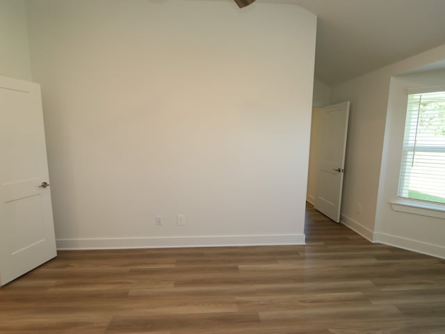 17343 Silver Birch Ct, New Caney, TX 77357 - empty room with vaulted ceiling, baseboards, and wood finished floors