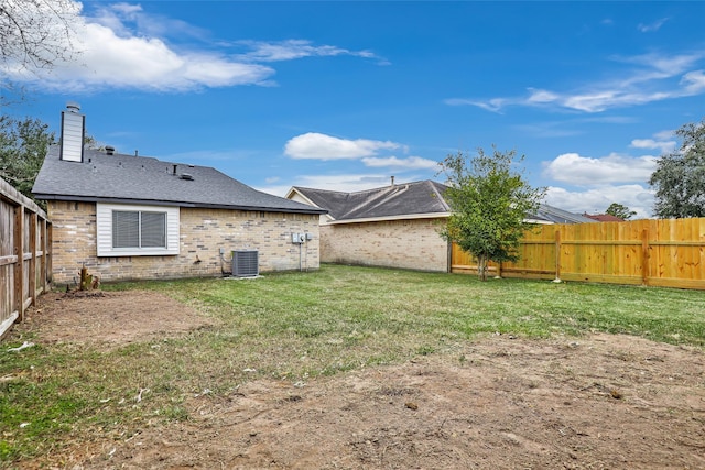 back of house with central AC and a lawn