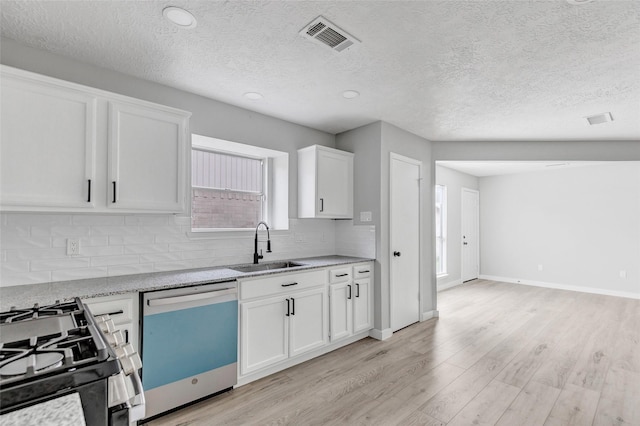 kitchen with light hardwood / wood-style floors, stainless steel appliances, light stone countertops, white cabinets, and sink