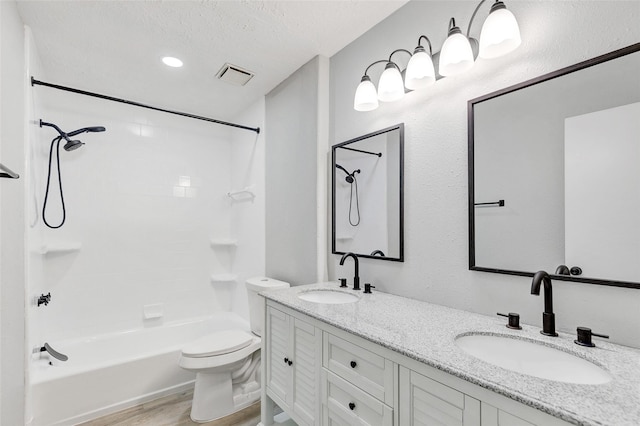 full bathroom featuring a textured ceiling, wood-type flooring, vanity, shower / bath combination, and toilet