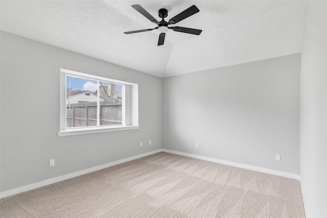 empty room featuring carpet floors, ceiling fan, a textured ceiling, and lofted ceiling