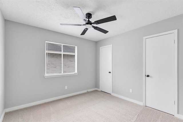 empty room with a textured ceiling, ceiling fan, and carpet floors